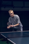 Young players practicing table tennis during a lively club training session.