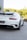 a white porsche sports car parked in front of a building
