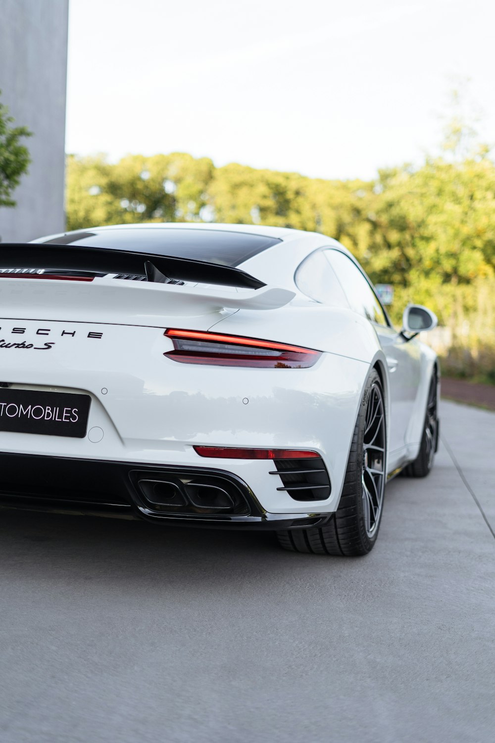 a white porsche sports car parked in front of a building