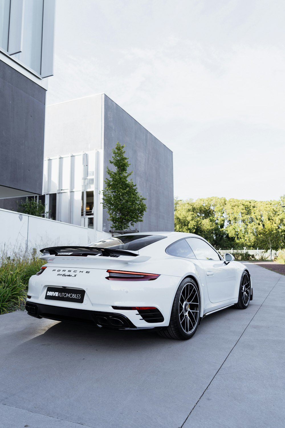 a white sports car parked in front of a building