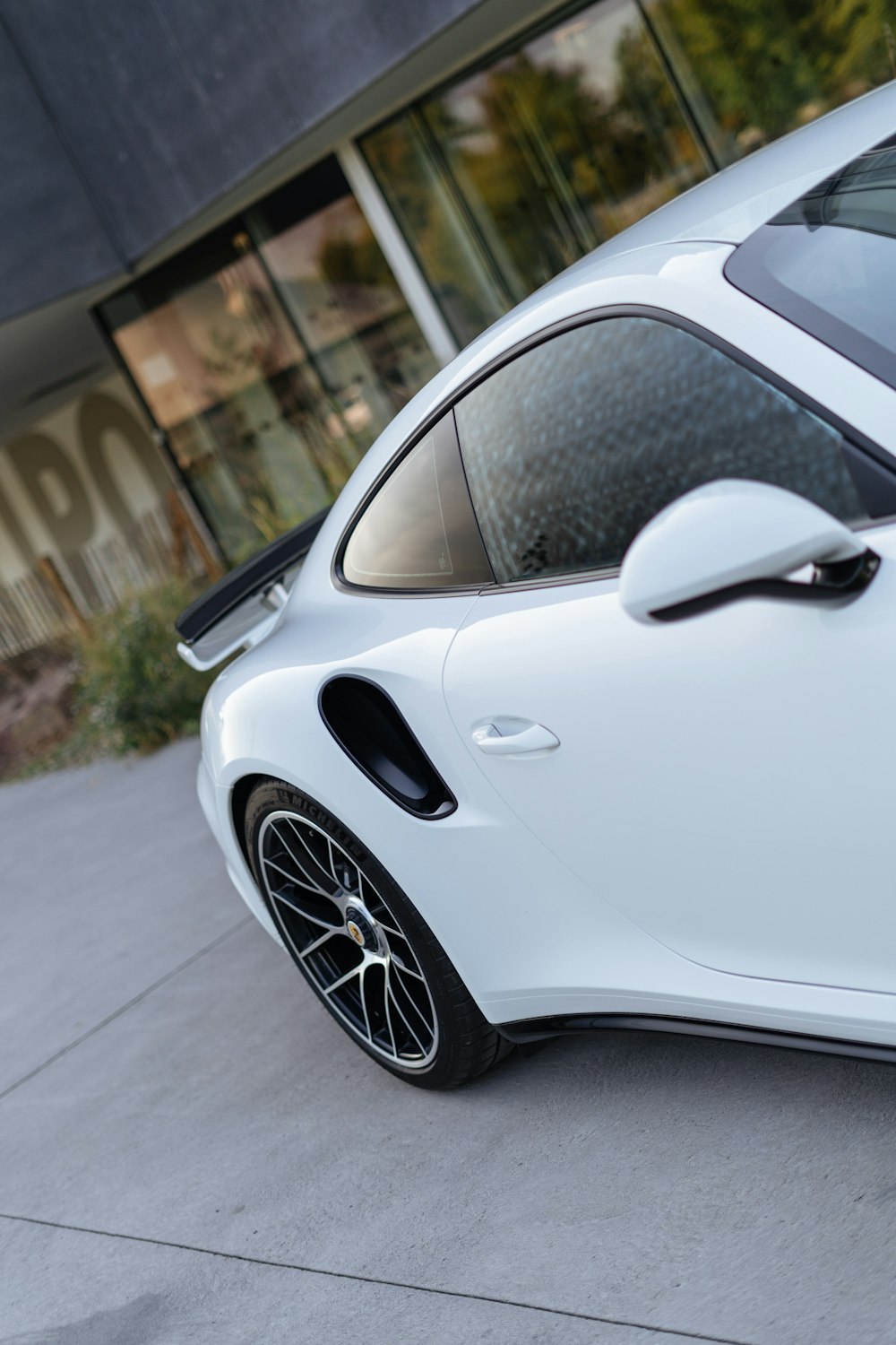 a white sports car parked in front of a building