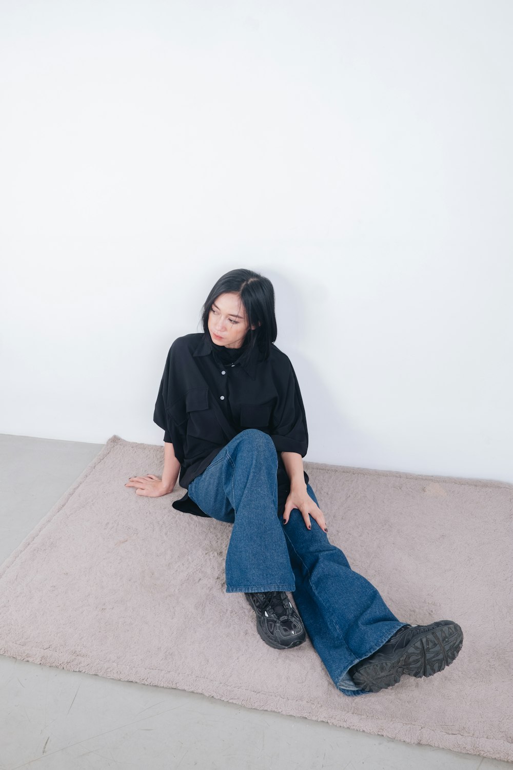 a woman sitting on the floor with her legs crossed
