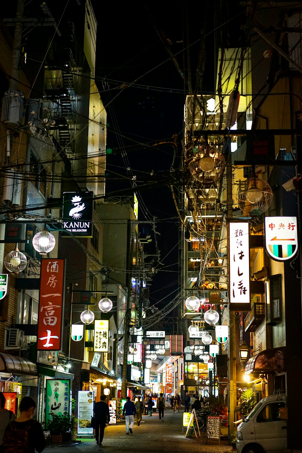 a city street at night filled with people and signs