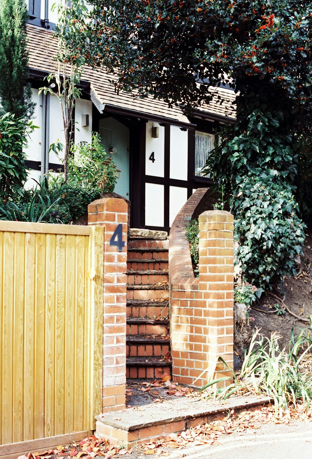 uma casa com uma cerca de madeira e um portão de madeira