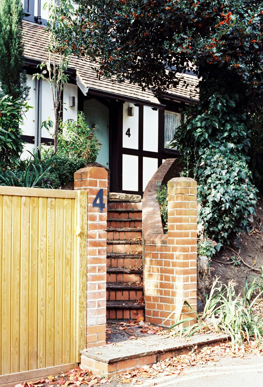 ein Haus mit einem Holzzaun und einem Holztor