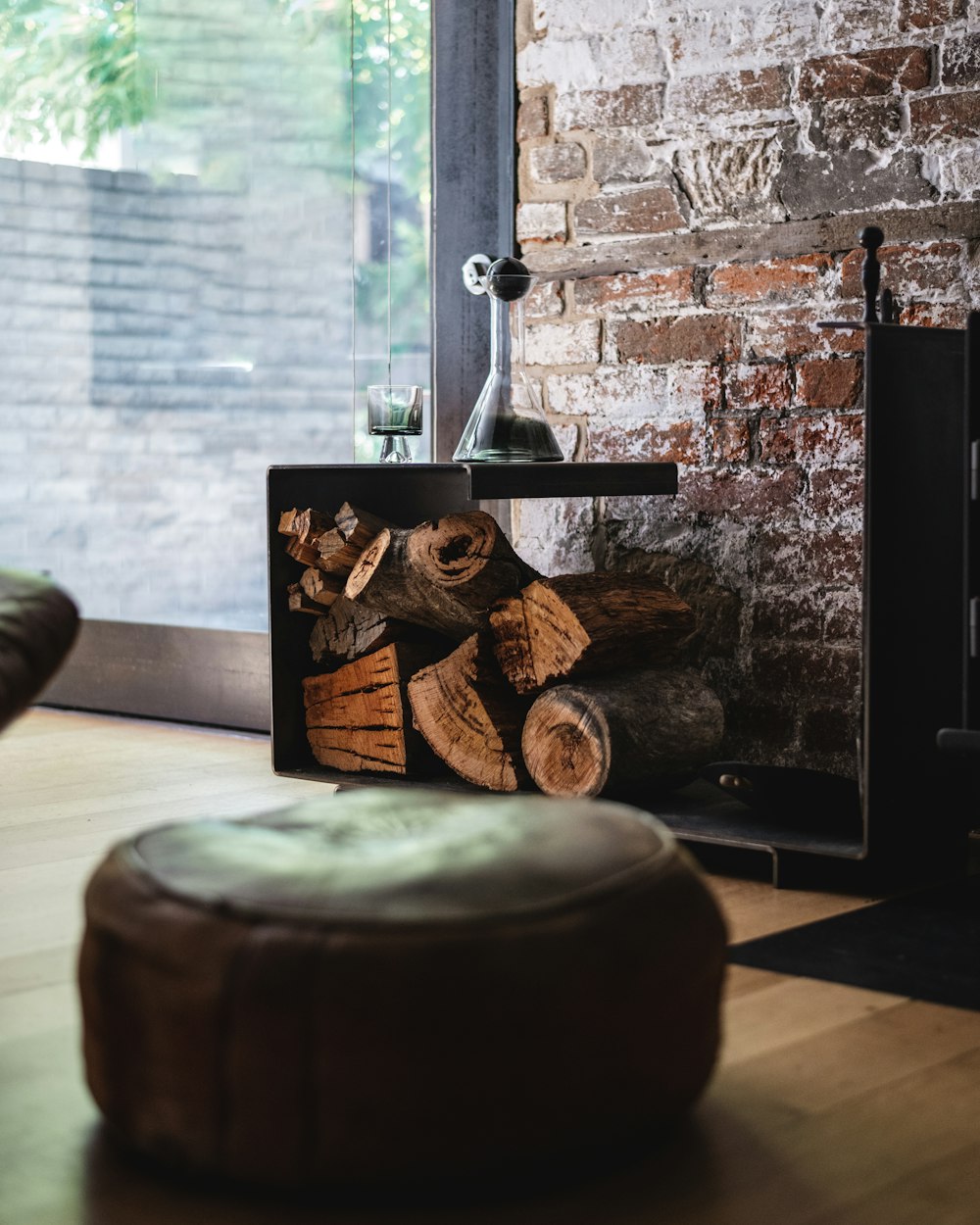 a fireplace with logs in front of a brick wall