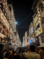 A vibrant street scene with colorful lights and joyful people celebrating an event