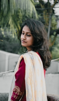 A serene woman meditating outdoors with colorful mystical patterns swirling around her.