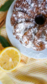 Elegant vanilla bundt cake sprinkled with powdered sugar and cinnamon sticks.