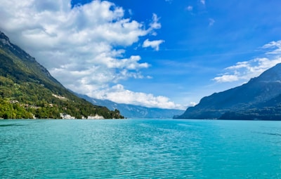 A serene view of Lake Louise with turquoise waters and surrounding mountains under a clear sky.