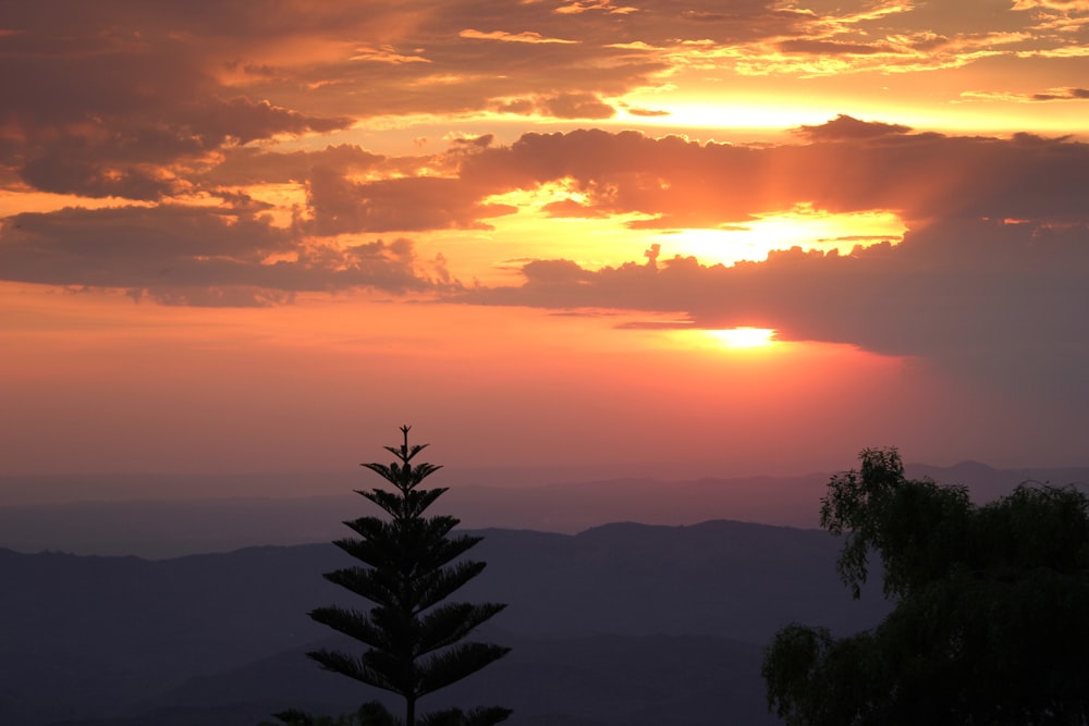 the sun is setting over a mountain range