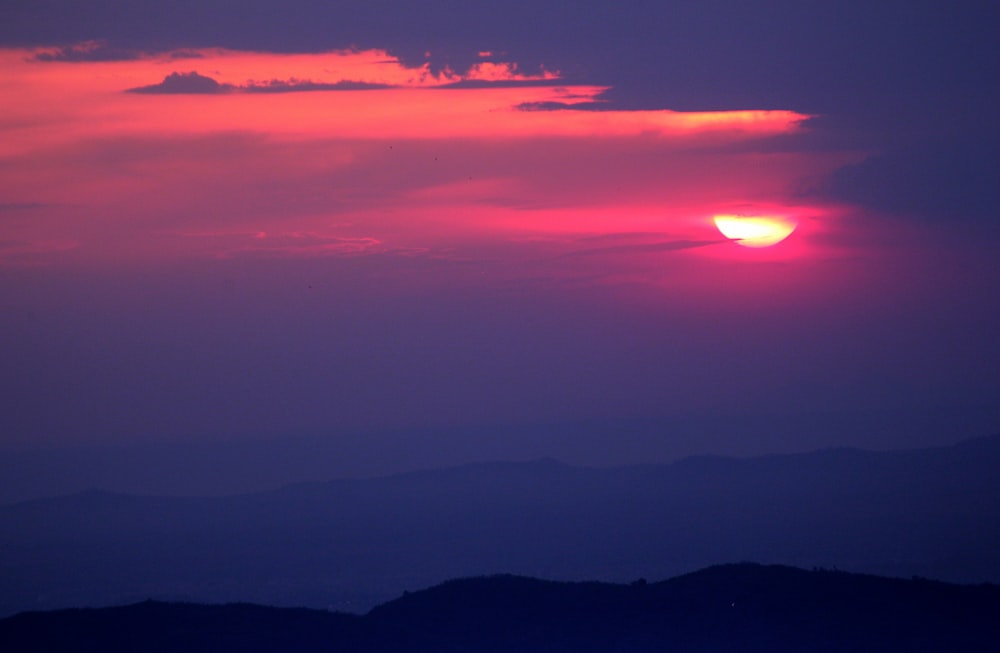 Il sole sta tramontando su una catena montuosa