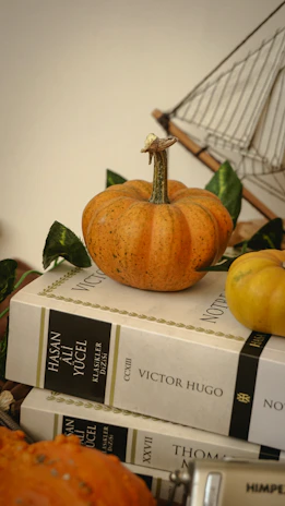 A stack of poetry books with autumn-themed bookmarks peeking out from the pages.
