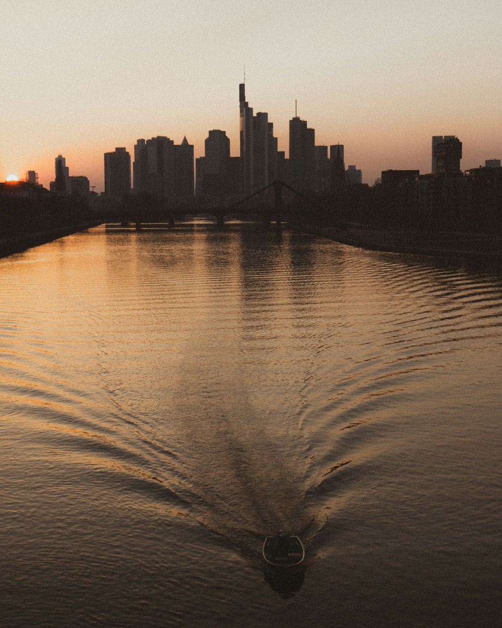 a boat traveling down a river next to a city