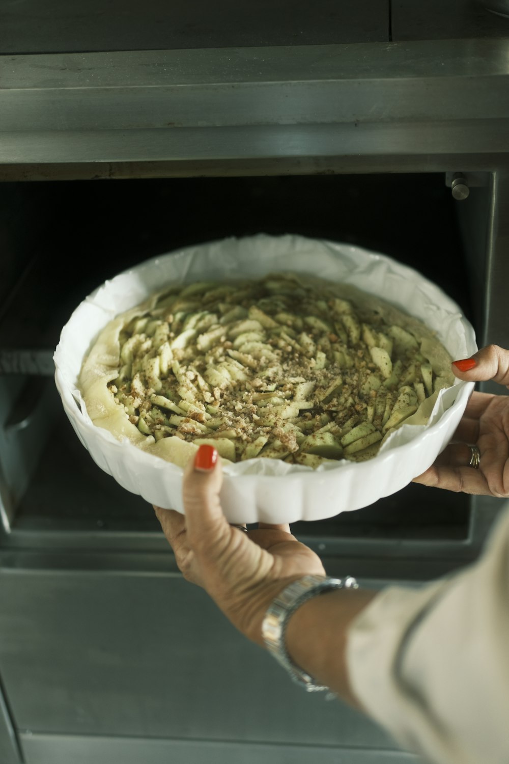 a person holding a bowl of food in front of an oven