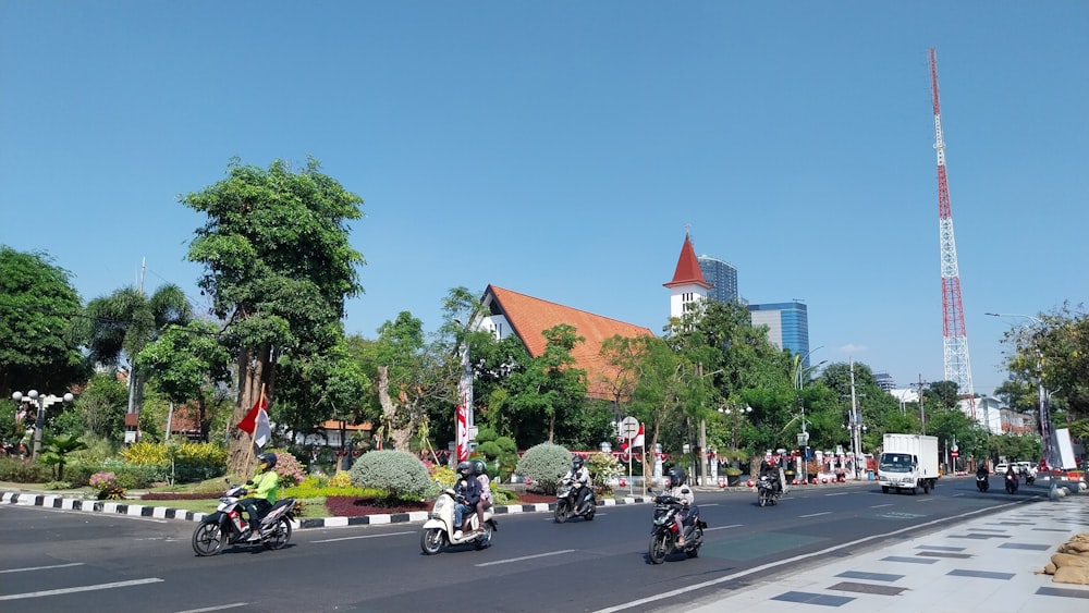 a group of people riding motorcycles down a street