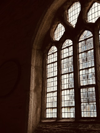 Elegant stained glass window casting soft light on a cream-colored wall.