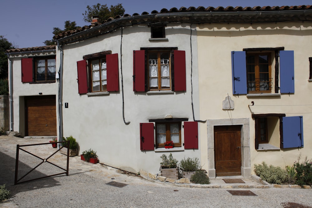 a house with red shutters and blue shutters