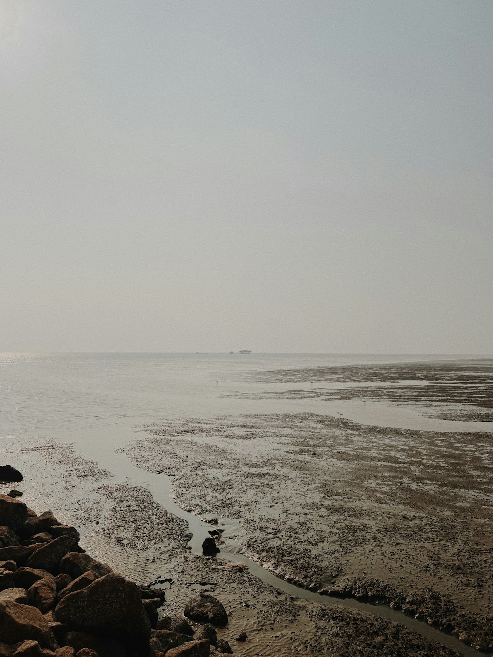 a rocky beach with a body of water in the distance