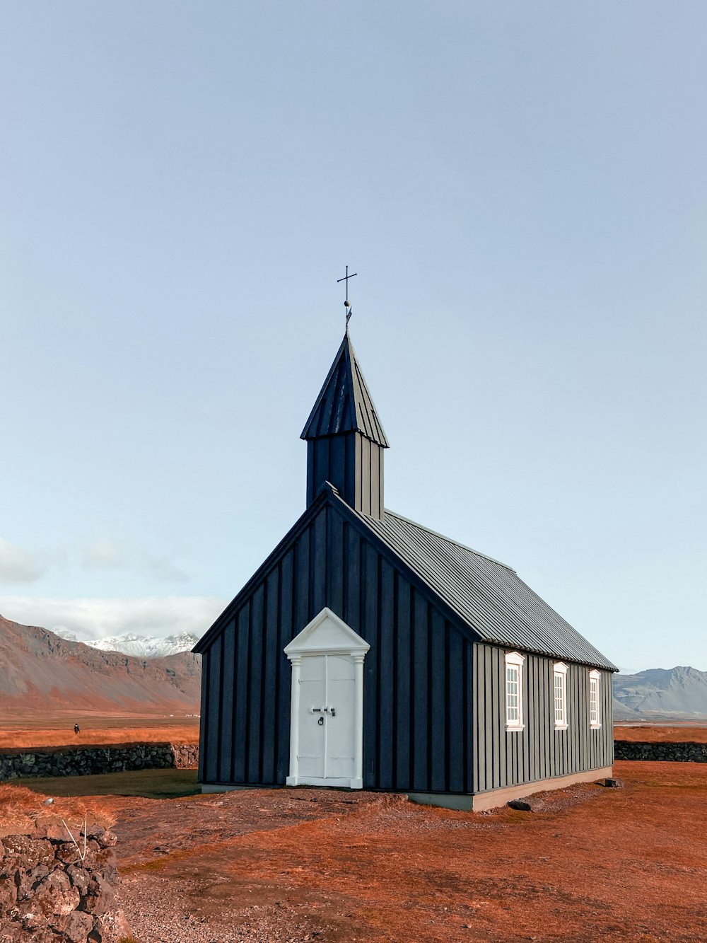 a small church with a steeple and a cross on top