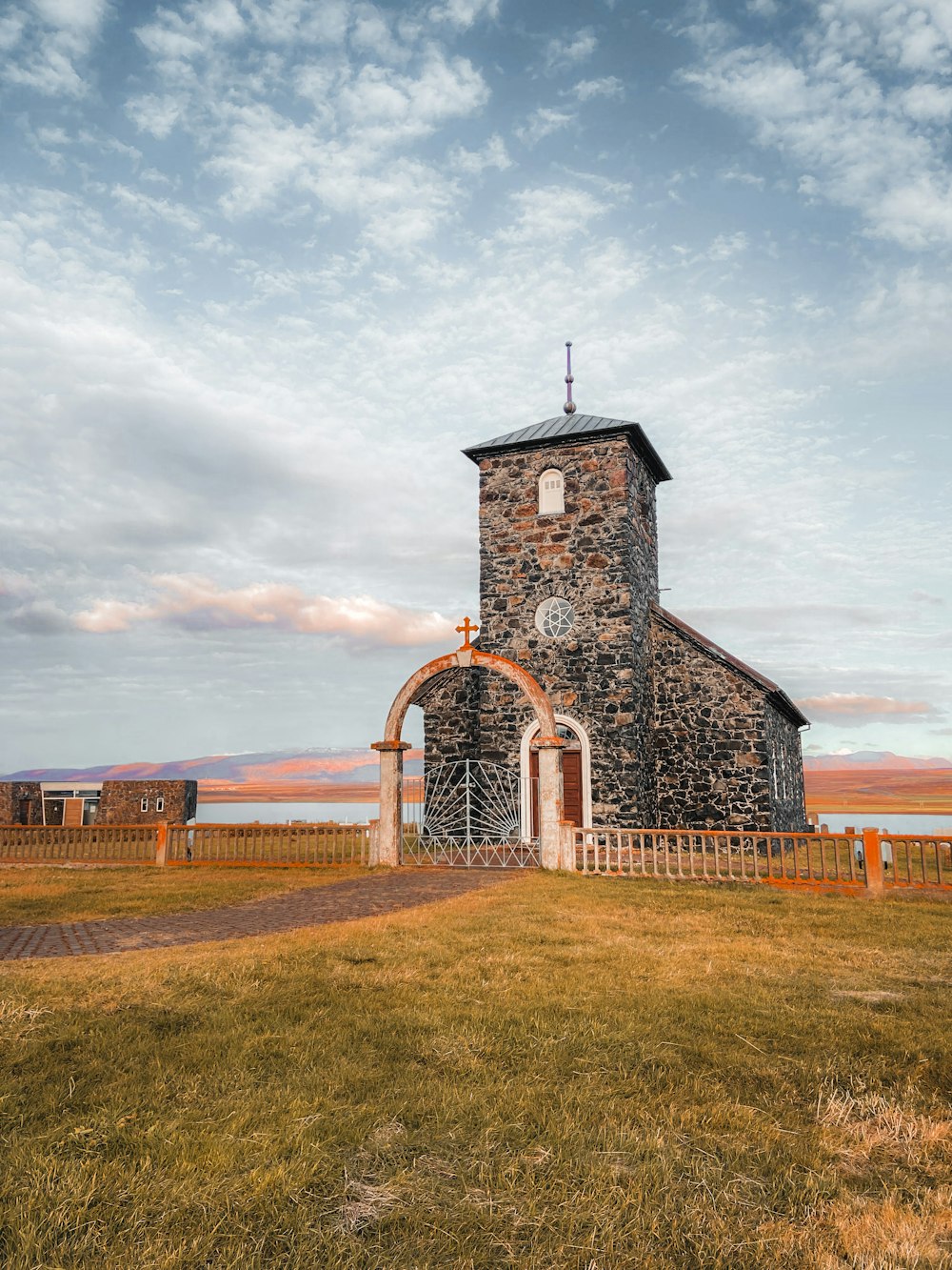 an old stone church with a gate in front of it