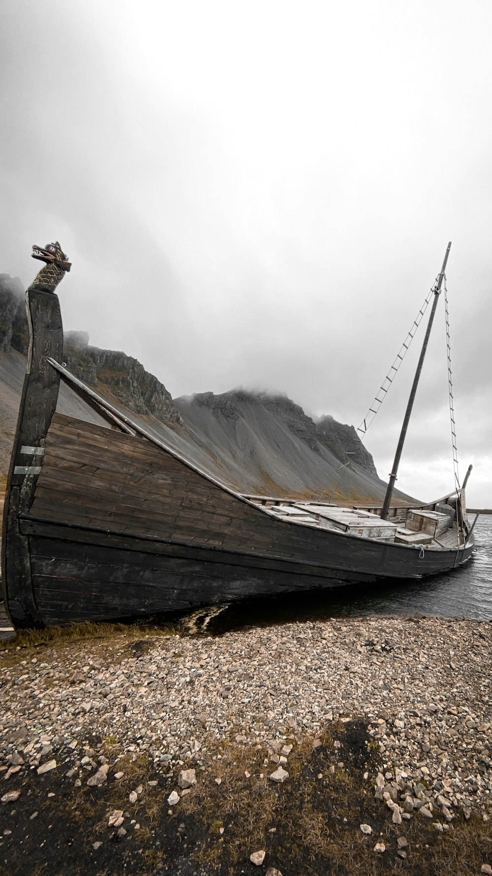 a boat sitting on top of a rocky beach