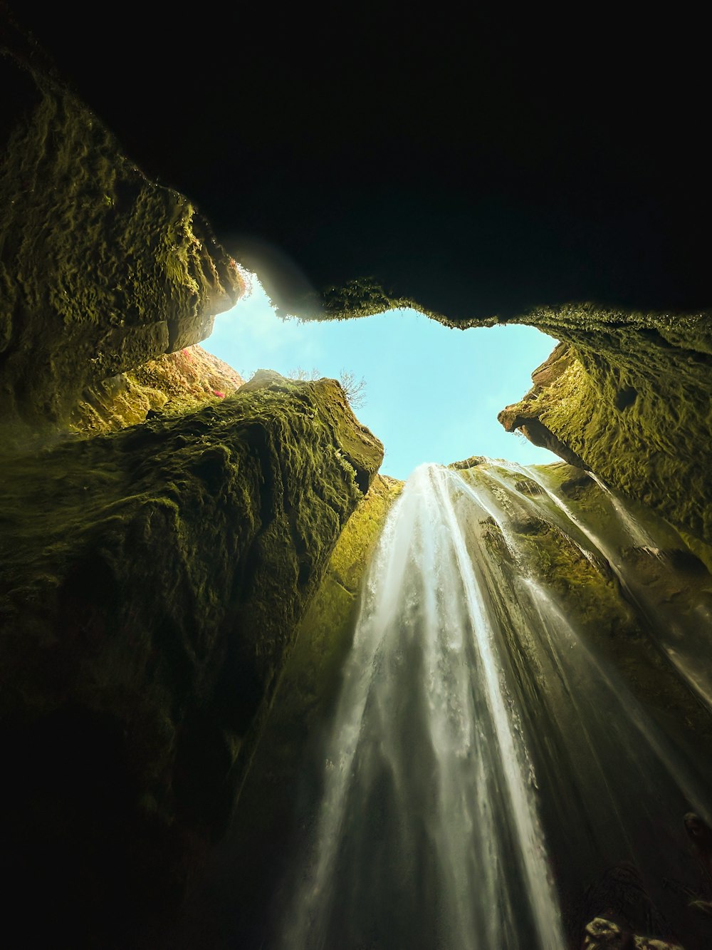 Blick auf einen Wasserfall vom Grund einer Höhle