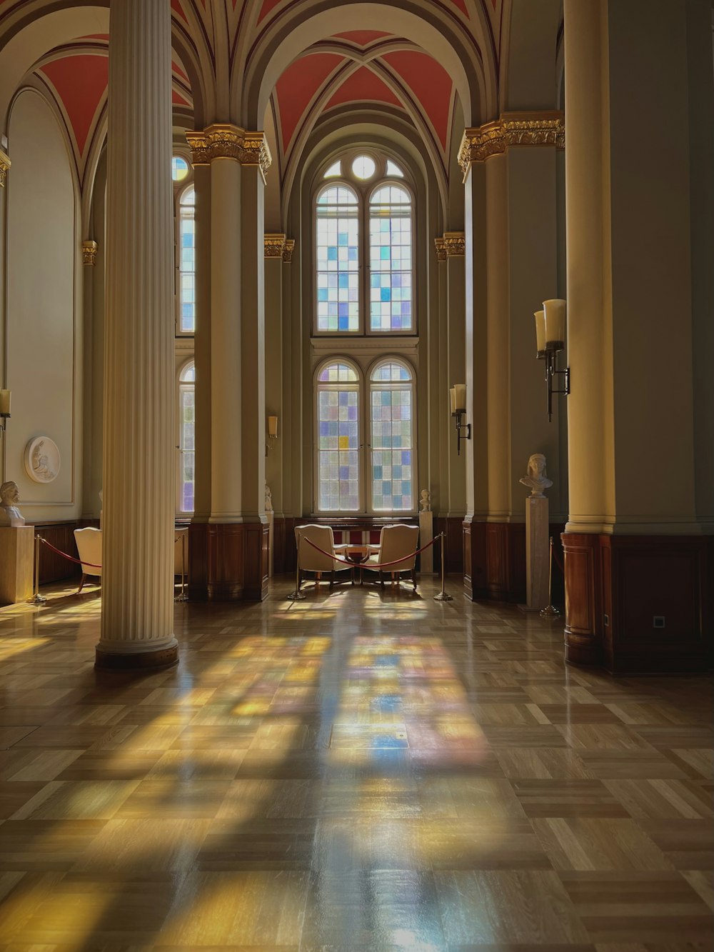 a large room with columns and stained glass windows