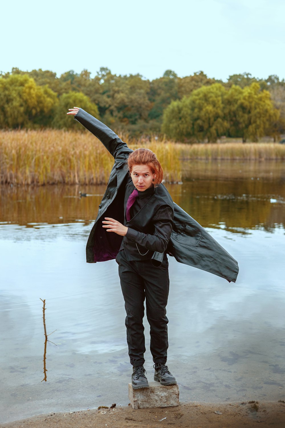 a woman standing on a rock in front of a body of water