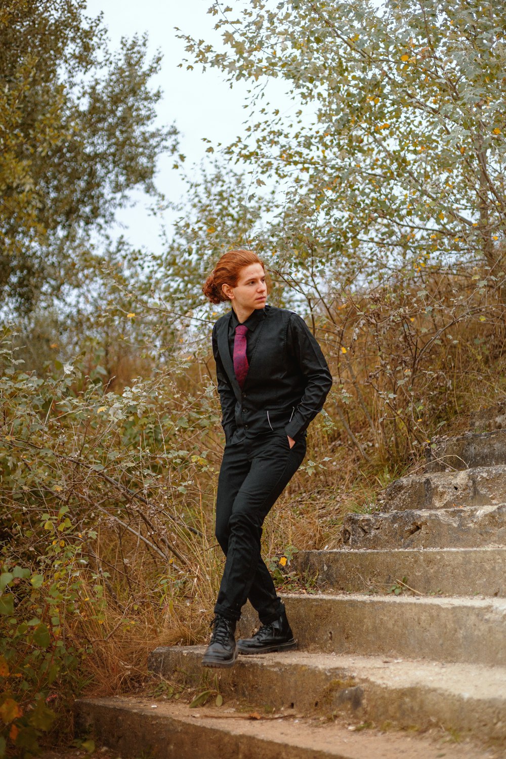 a woman in a suit standing on some steps