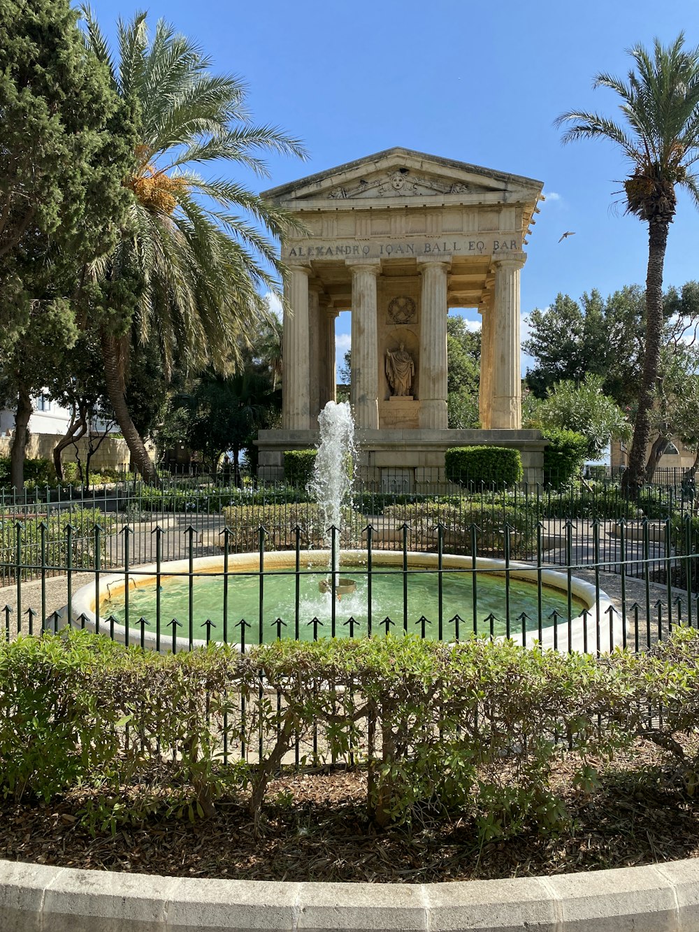 a fountain in a park surrounded by trees