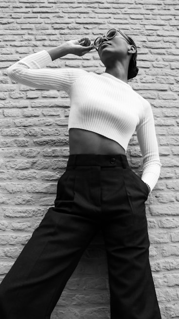 Model wearing a cream co-ord set standing against a sleek black wall, hands in pockets