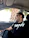 Close-up of a satisfied customer smiling next to their car with newly installed tinted windows.