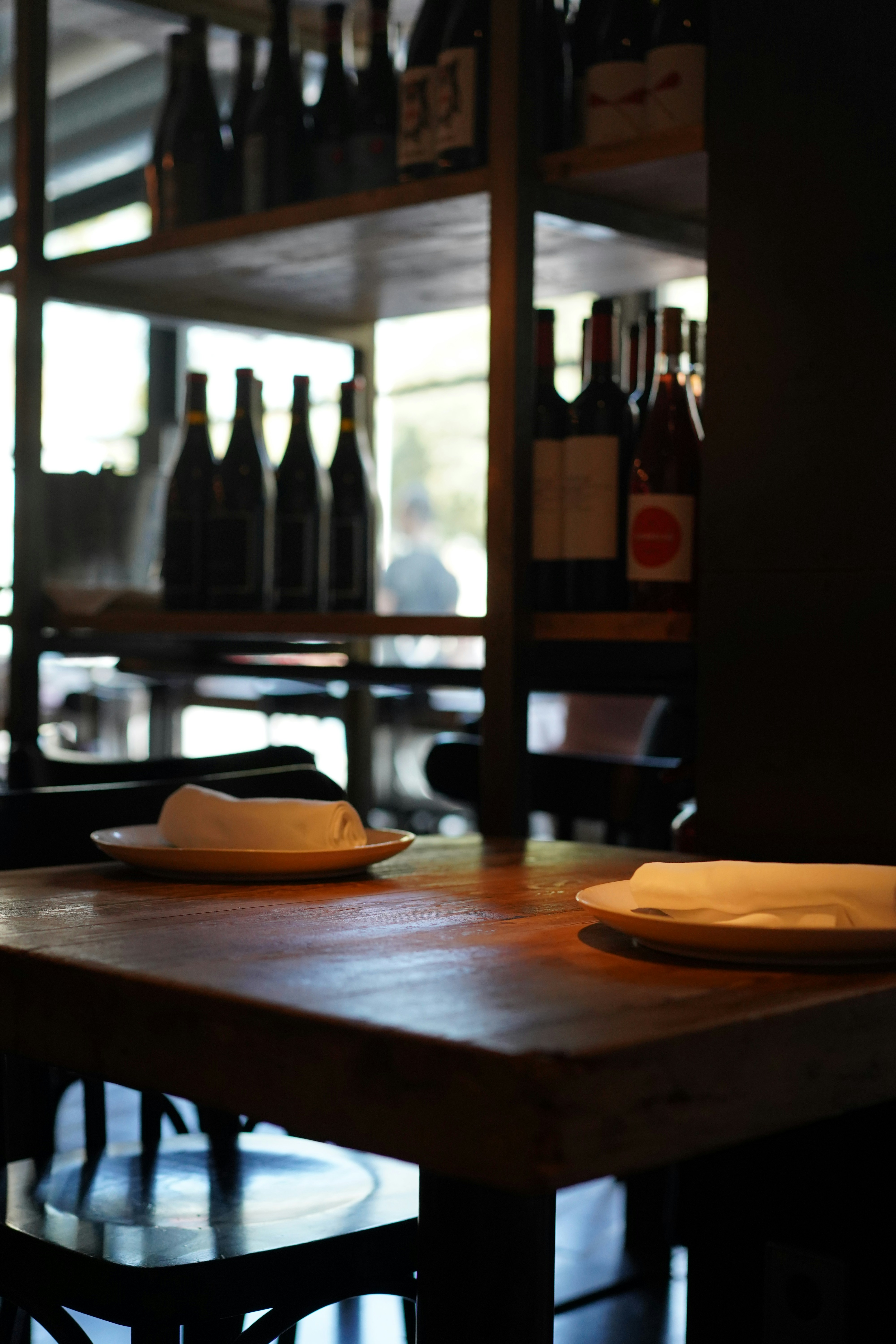 a wooden table topped with plates and bottles of wine