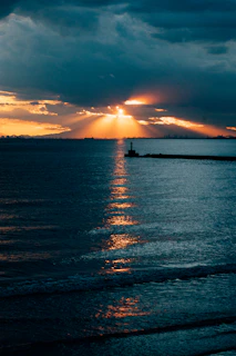 An artistic rendering of the Creac'h lighthouse outline with golden rays spreading left and right.