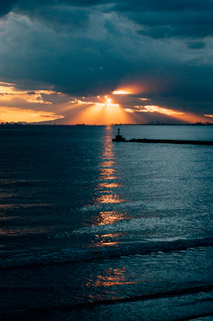 An artistic rendering of the Creac'h lighthouse outline with golden rays spreading left and right.