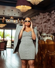 A stylish woman wearing a chic outfit in a bright setting.