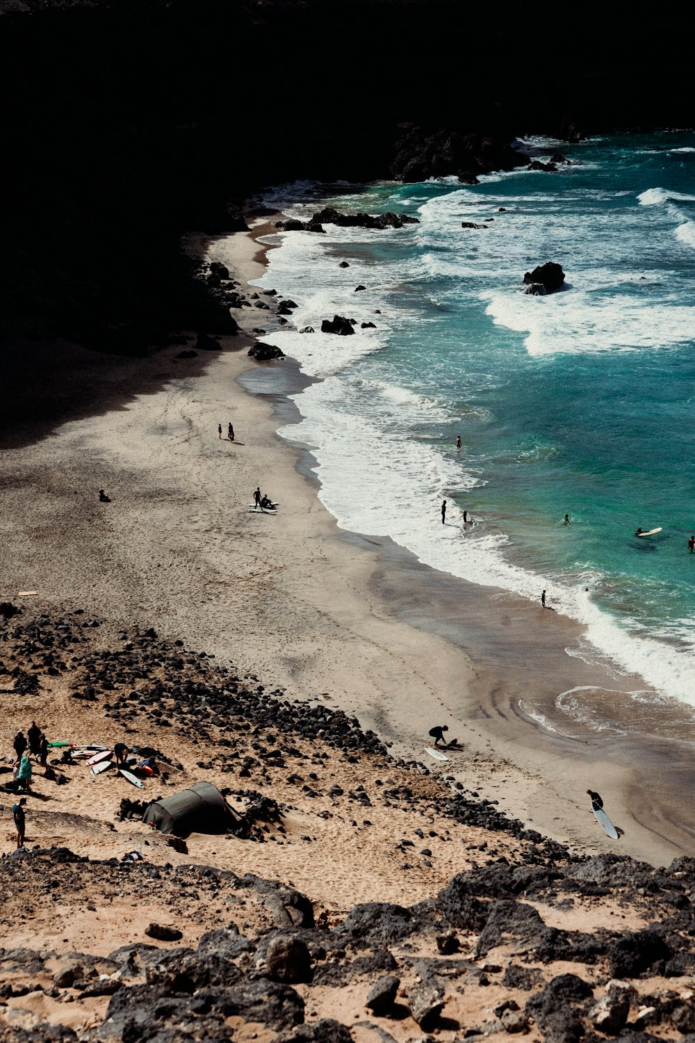 a group of people standing on top of a sandy beach