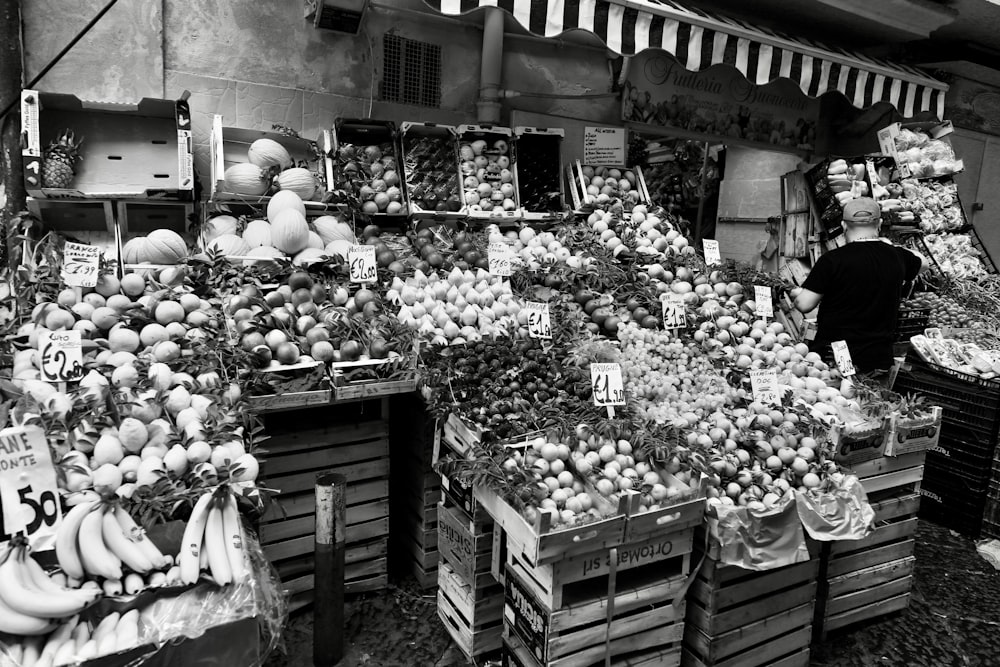 a black and white photo of a fruit stand