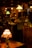 A dimly lit antique shop with various vintage objects, including lamps with stained glass and colored shades. Shelves are filled with decorative items and furniture, creating a nostalgic and cozy atmosphere.