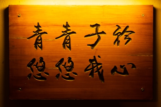 a wooden sign with asian writing on it