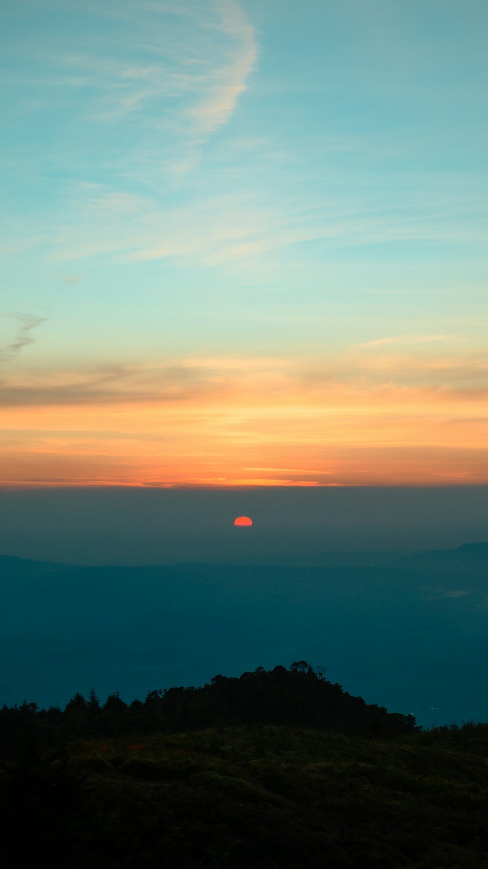 Die Sonne geht über einer Bergkette unter