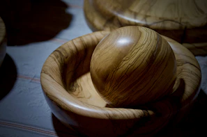 A smooth wooden bowl with natural grain patterns shining in soft light.