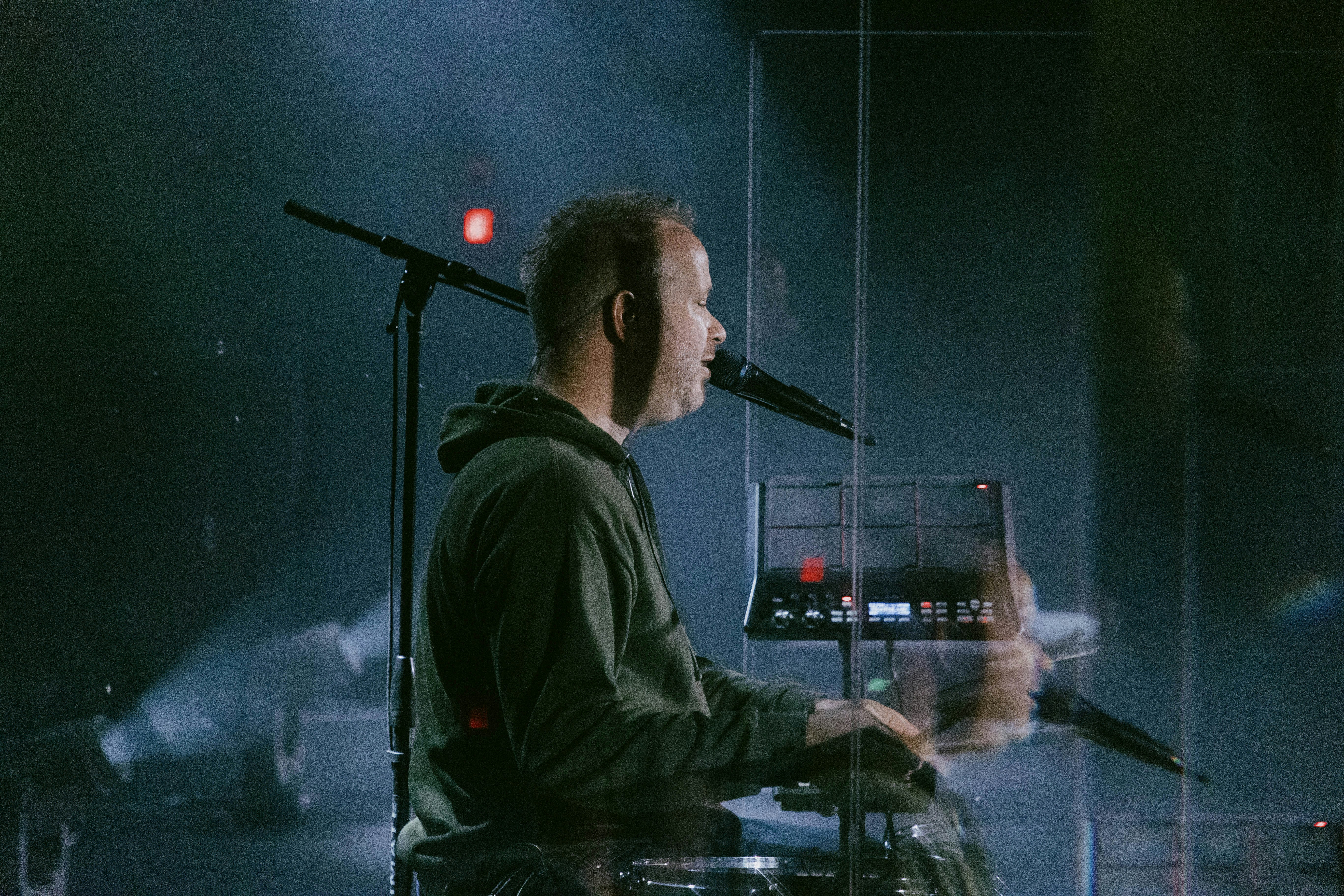 a man playing a keyboard in front of a microphone