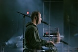 a man playing a keyboard in front of a microphone