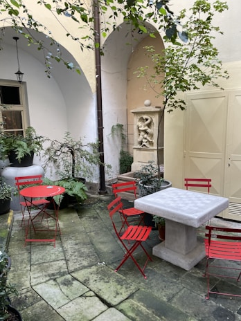 Charming courtyard of Hôtel du Bellay with ivy-covered walls and cozy outdoor seating.