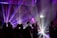 A lively DJ setup with colorful lights illuminating a dance floor filled with happy guests.