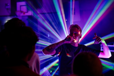a man singing into a microphone in front of a crowd