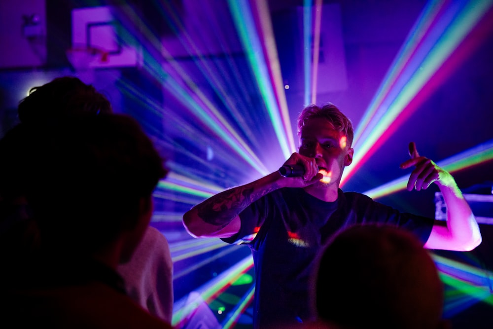 a man singing into a microphone in front of a crowd