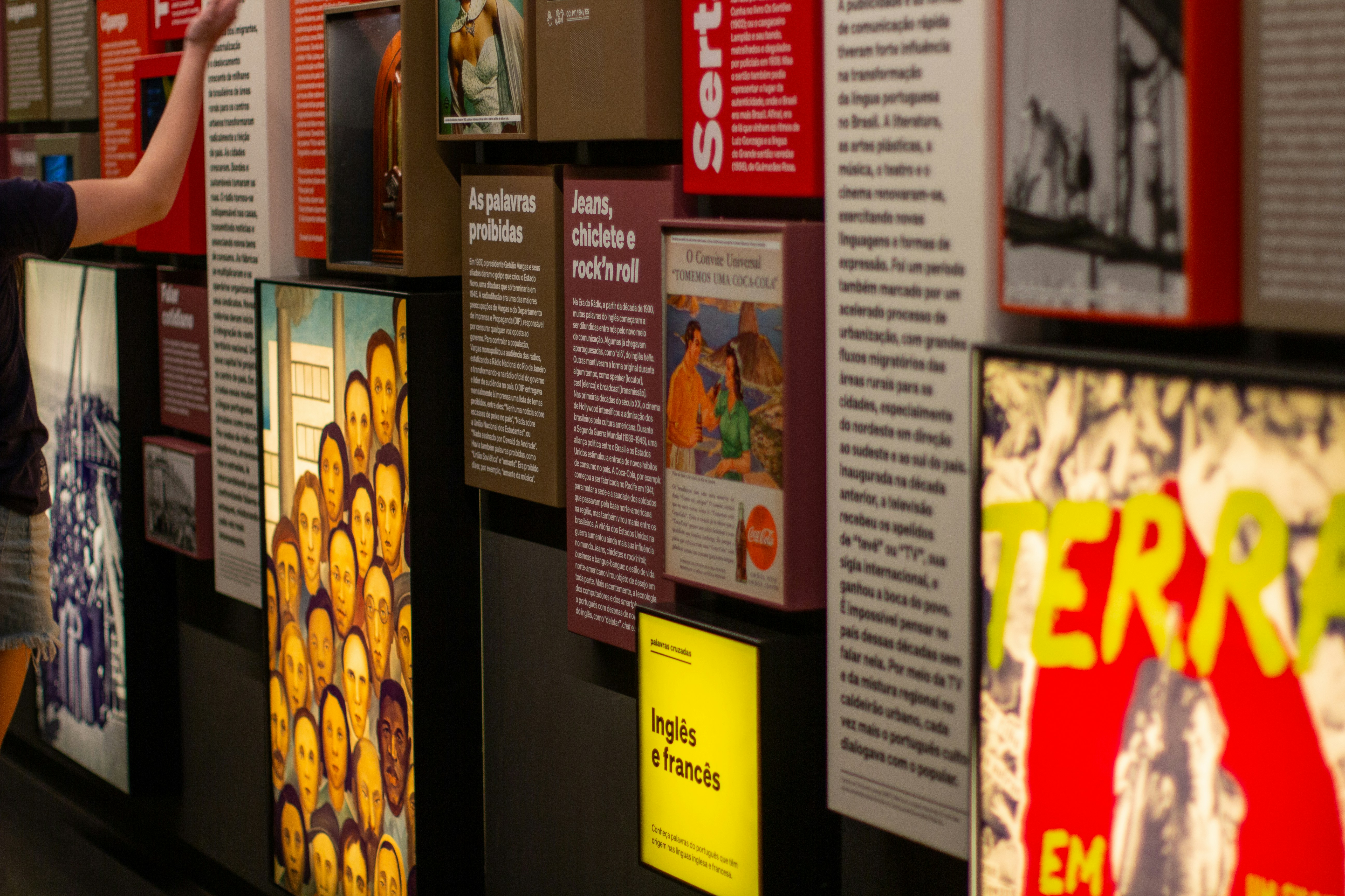 a woman pointing at a wall with posters on it